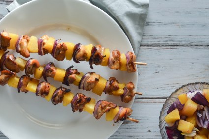 These pineapple chicken kabobs are fantastic for anyone looking for a fun party recipe, or can be made for a family dinner in the oven simply by baking and broiling! The chicken is marinated in a pineapple honey sauce and then placed on the skewer between layers of red onion and pineapple. Paleo, gluten-free, grain-free, refined sugar free.